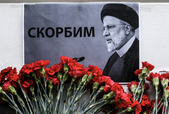 epa11355324 The portrait of the late Iranian President Ebrahim Raisi is displayed among flowers laid outside the Iranian embassy, following the deaths of Iran&#039;s president Raisi and Foreign Minist ...