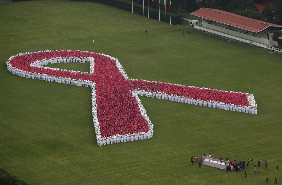 Thousands of people form a giant pink ribbon during an event marking the start of breast cancer awareness month, inside the grounds of a military camp in Mexico City, Saturday, Oct. 1, 2016. Organizer ...