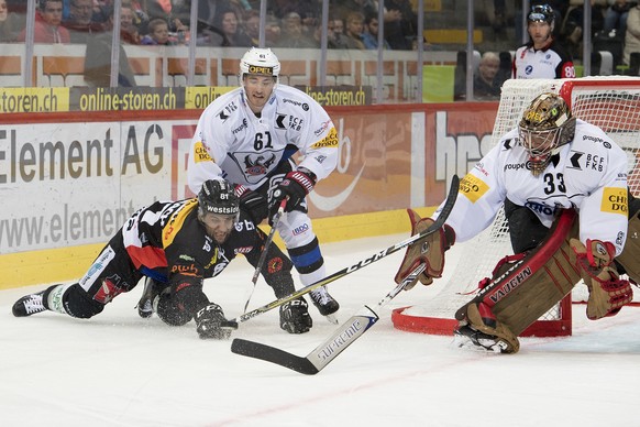 Berns Thomas Ruefenacht, links, Fribourgs Lorenz Kienzle, mitte, und Fribourgs Goalie Barry Brust, rechts, kaempfen um den Puck, beim Eishockey Meisterschaftsspiel der National League zwischen den SC  ...