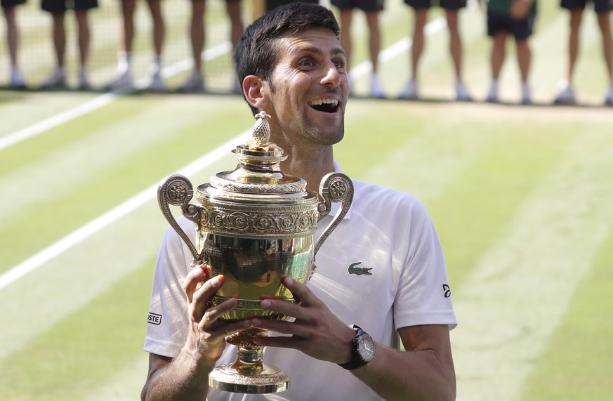 FILE - In this July 15, 2018, file photo, Serbia&#039;s Novak Djokovic holds the trophy after winning the men&#039;s singles final match against Kevin Anderson of South Africa, at the Wimbledon Tennis ...
