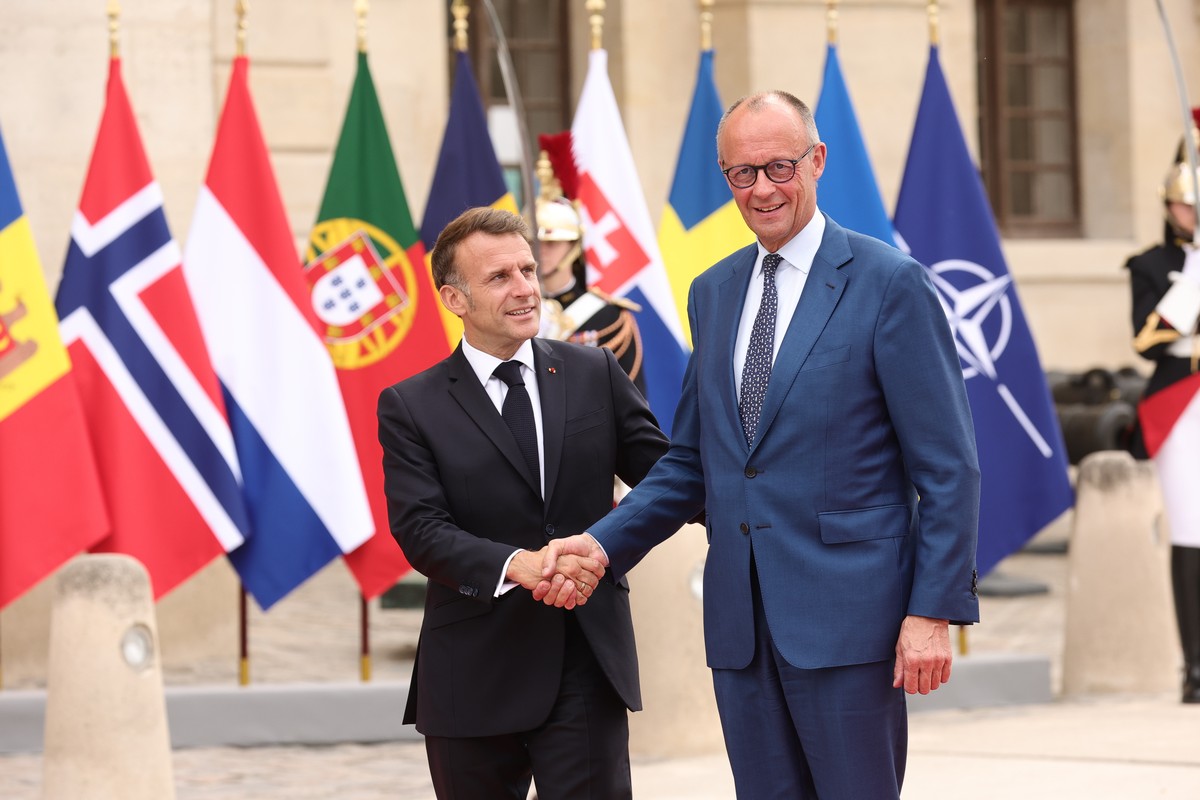 French President Emmanuel Macron, left, greets German Chancellor Friedrich Merz ahead of the Coalition of the Willing summit on security guarantees for Ukraine, at the Hotel des Invalides in Paris, Mo ...