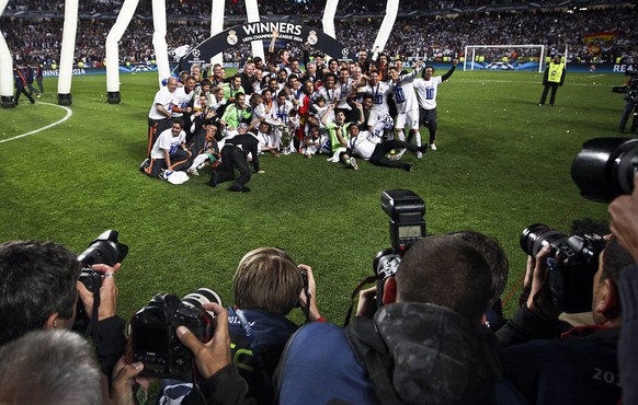 epa04223515 Real Madrid players celebrate with the trophy after the UEFA Champions League final between Real Madrid and Atletico Madrid at Luz stadium in Lisbon, Portugal, 24 May 2014. Real Madrid bec ...