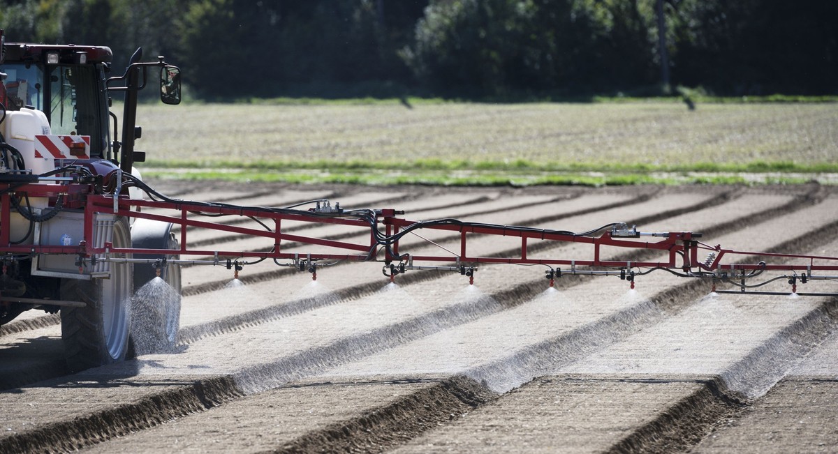 After the spinach seeds were sown in a field on the Gemuese Kaeser &amp; Co. farm in Birmenstorf, Switzerland, a tractor with a field sprayer system applies a herbicide which reduces the germination o ...