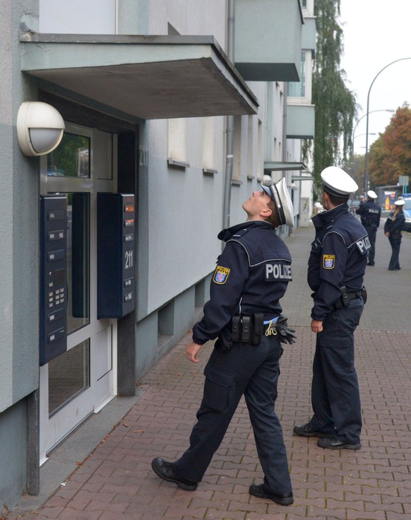 epa06180609 Police officers check buildings in the danger zone for residents who have not yet been evacuated from the area around the site of a World War II dud bomb find in Frankfurt/Main, Germany, 0 ...