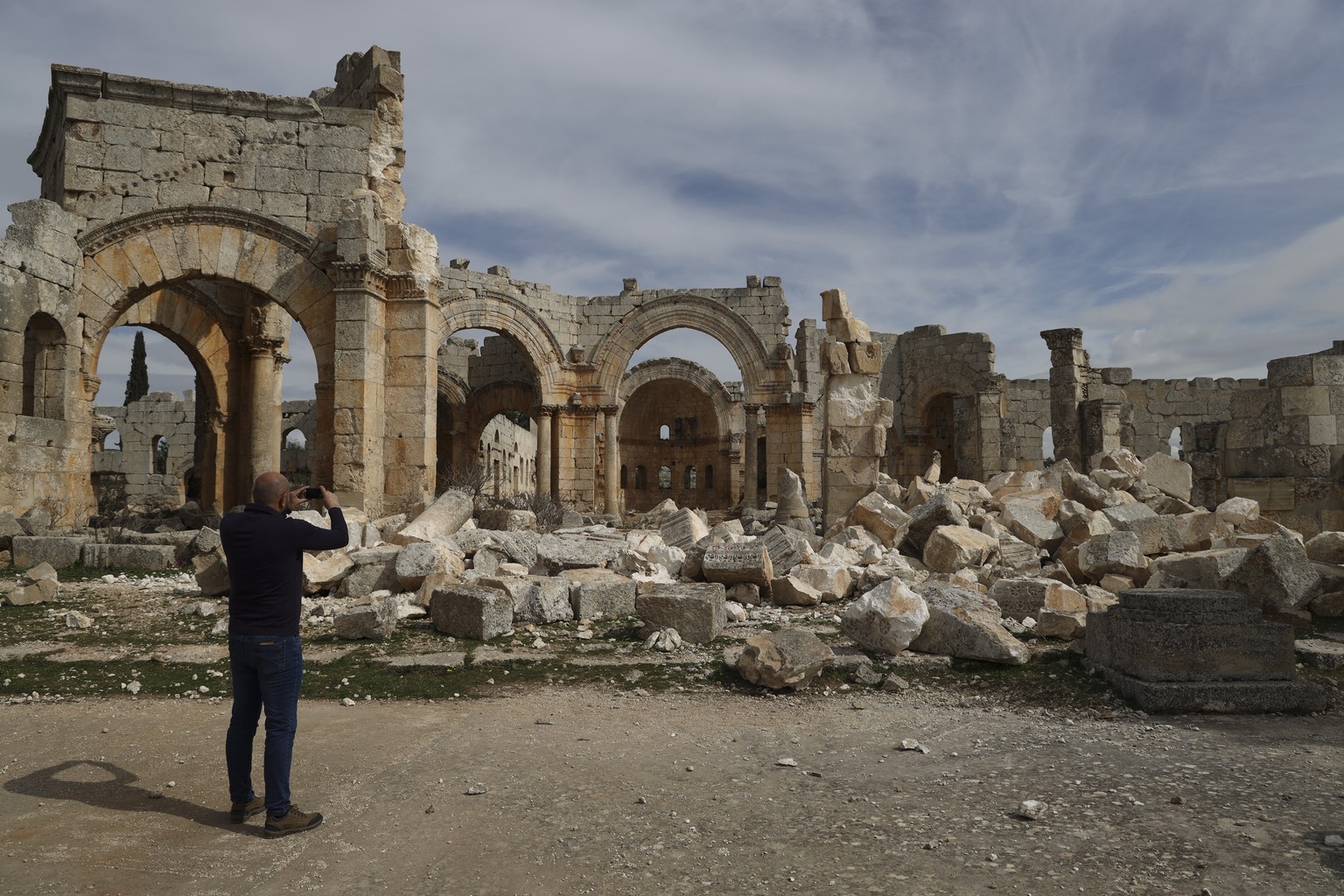 A man photographs the Church of Saint Simeon 30 kilometers (19 miles) northwest of Aleppo, Syra, Wednesday, March 8, 2023. The Byzantine-era church suffered destruction during the war and was further  ...