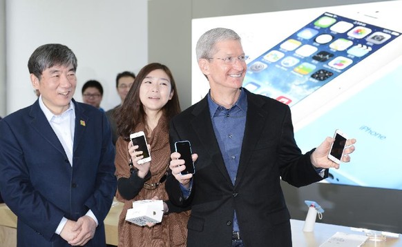 Apple-Chef Tim Cook posiert mit vermögenden Chinesen, die sich das iPhone als Statussymbol leisten.