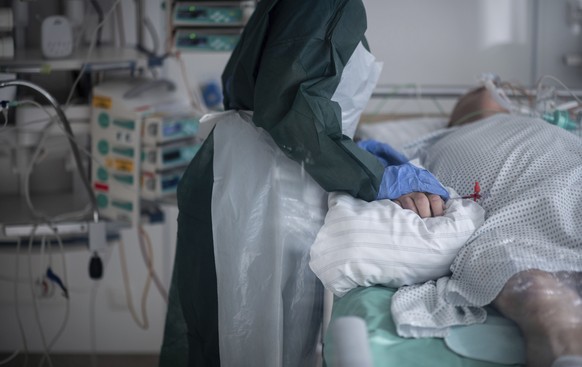 Nursing staff in protective equipment cares for a corona patient in a hospital in Essen, Germany, Wednesday, Oct. 28, 2020. People with a new coronavirus infection are treated in the intensive care un ...