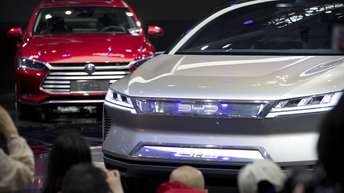 FILE - Attendees take photos of the E-SEED electric concept car during a press conference by Chinese automaker BYD at the China Auto Show in Beijing, on April 25, 2018. China's Commerce Ministry  ...