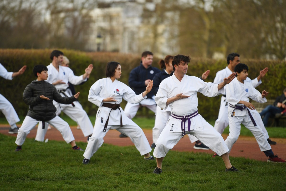 epaselect epa08312054 People practice martial arts in Primrose Hill in London, Britain, 21 March 2020. Britain's Prime Minister Boris Johnson has urged UK citizens to avoid unnecessary social con ...