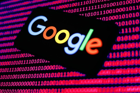 Google logo displayed on a phone screen and a binary code displayed on a screen are seen in this illustration photo taken in Krakow, Poland on January 15, 2023. (Photo by Jakub Porzycki/NurPhoto via G ...