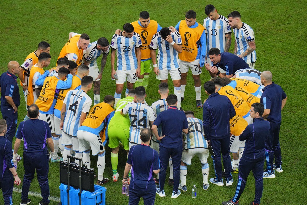 Argentina's head coach Lionel Scaloni talks with players before the start of the extra time during the World Cup final soccer match between Argentina and France at the Lusail Stadium in Lusail, Q ...