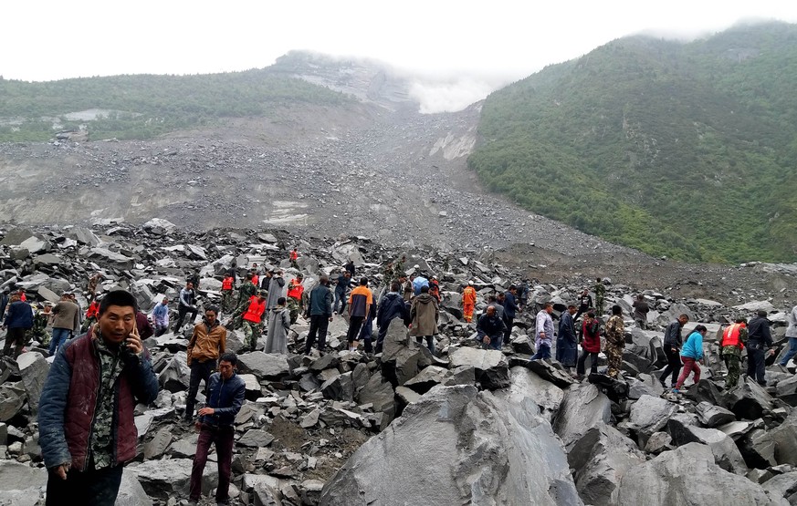 epa06046810 Rescuers work at the site of a massive landslide where over 100 villagers are estimated buried in the early morning disaster in Maoxian county, in southwest China&#039;s Sichuan province,  ...