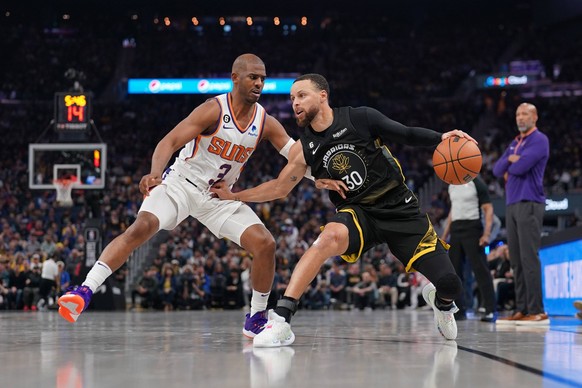 NBA, Basketball Herren, USA Phoenix Suns at Golden State Warriors Mar 13, 2023 San Francisco, California, USA Golden State Warriors guard Stephen Curry 30 dribbles the ball next to Phoenix Suns guard  ...