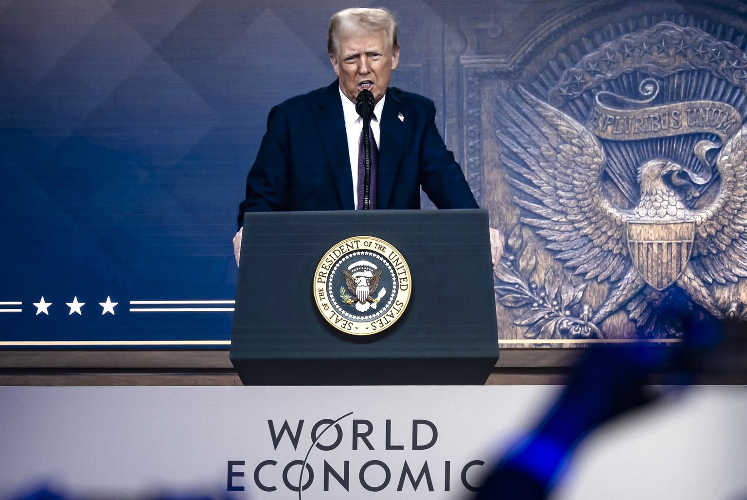 epa11847765 US President Donald J. Trump is shown on a screen as he addresses via remote connection a plenary session in the Congress Hall during the 55th annual meeting of the World Economic Forum (W ...
