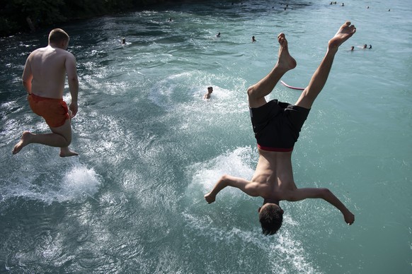 People jump from a bridge in the Aare River during the sunny and warm weather, in Bern. Switzerland, Wednesday, June 26, 2019. The forecasts predict hot weather in Switzerland with the maximum tempera ...