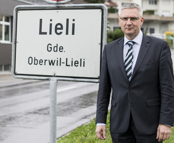 Andreas Glarner, Gemeindeammann Oberwil-Lieli, posiert eingangs Dorf Lieli vor der Ortstafel in Oberwil-Lieli, Kanton Aargau, am Mittwoch, 23. September 2015. Im Hintergrund links das Gebaeude seines  ...