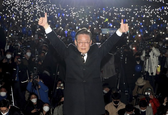 Lee Jae-myung, the presidential candidate of the ruling Democratic Party, raises his hands during a presidential election campaign in Seoul, South Korea, Tuesday, March 8, 2022. South Korea&#039;s pre ...