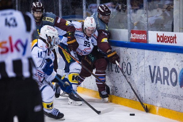 l?attaquant genevois Daniel Winnik, gauche, a la lutte pour le puck avec le defenseur zurichois Mika Henauer, centre, et l&#039;attaquant genevois Teemu Hartikainen, droite, lors du match du championn ...