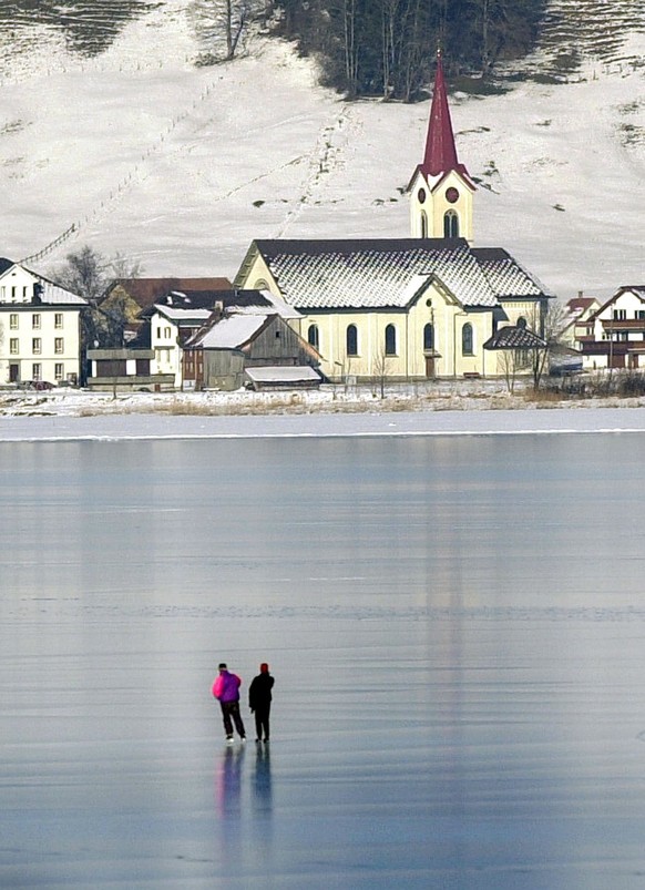 Schlittschuhlaeufer fahren am Dienstag, 16. Januar 2001, auf dem Sihlsee auf die Ortschaft Willerzell zu. Einige Wagemutige zog es bei strahlendem Sonnenschein auf die zugefrorene Flaeche. (KEYSTONE/S ...