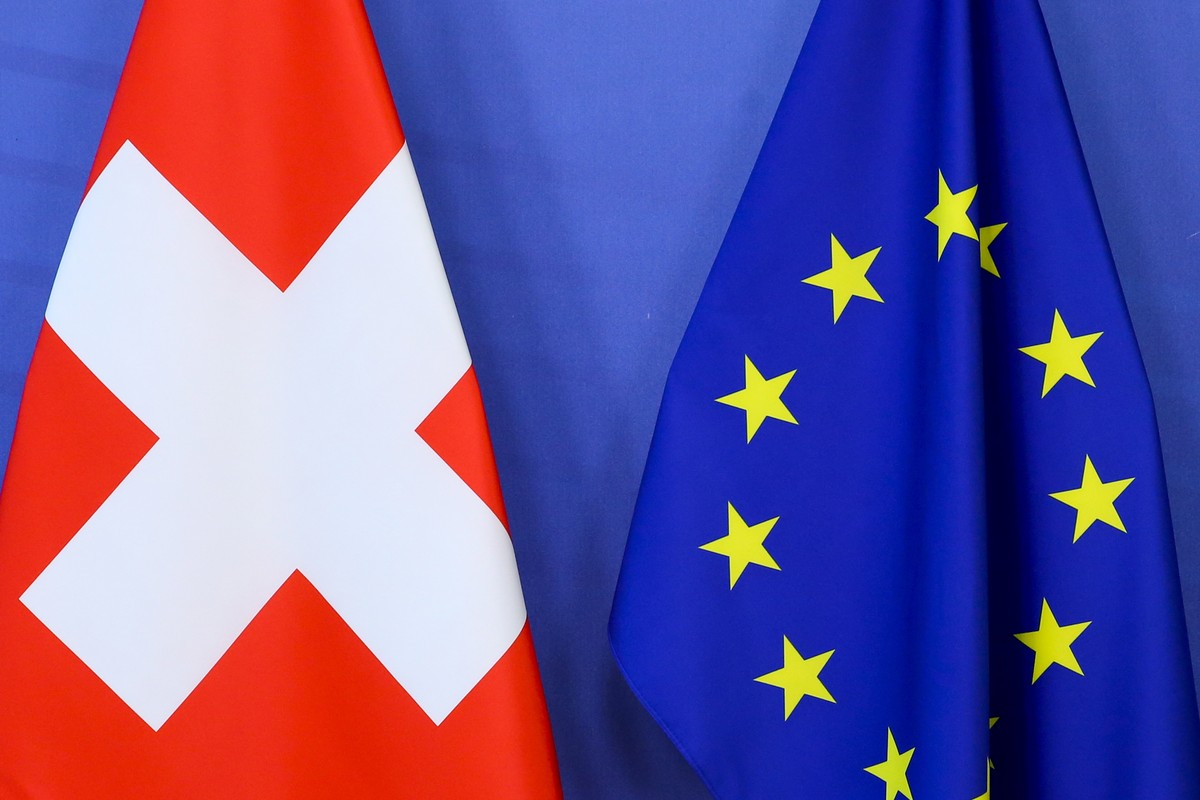 epa09155081 Switzerland's national flag (L) and te European Union flag at the European Commission building in Brussels, Belgium, 23 April 2021. EPA/FRANCOIS WALSCHAERTS / POOL