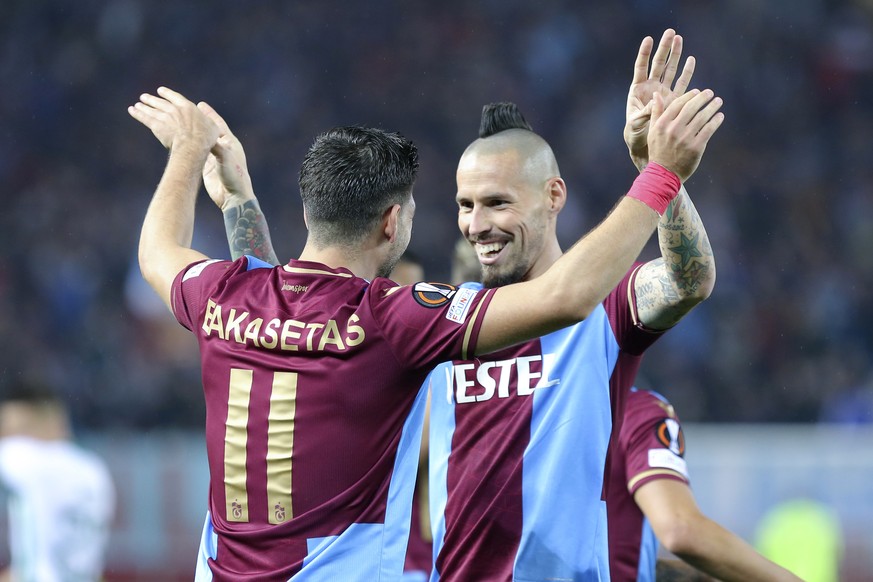 Trabzonspor&#039;s Anastasios Bakasetas, left, celebrates with teammate Marek Hamsik after scoring the opening goal during the Europa League group H soccer match between Trabzonspor and Ferencvaros at ...