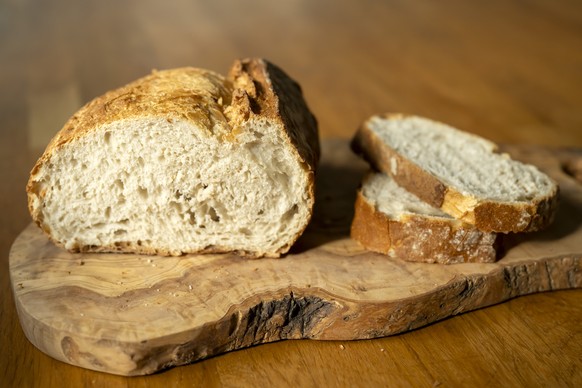 Brotscheiben und ein Laib Brot auf einem Holzbrett, fotografiert in Basel, am Donnerstag, 6. November 2025. (KEYSTONE/Georgios Kefalas)