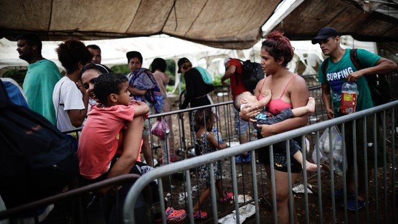 epa10877285 Migrants wait in line for a bus transfer to Paso Canoas, a city on the border with Costa Rica, after crossing the Darien jungle, in Lajas Blancas, Panama, 15 September 2023 (issued 22 Sept ...