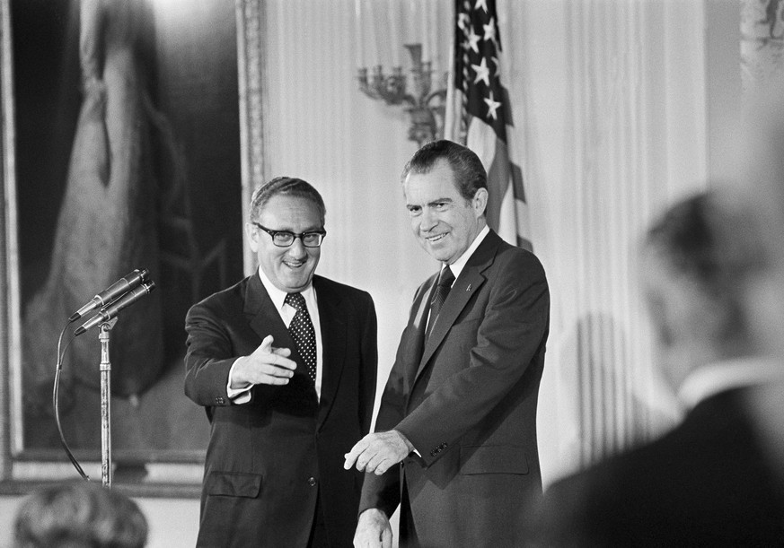 FILE - Secretary of State Henry Kissinger, left, gestures to the audience in the East Room of the White House, Sept. 22, 1973, as President Richard Nixon watches, in Washington. Kissinger had just bee ...