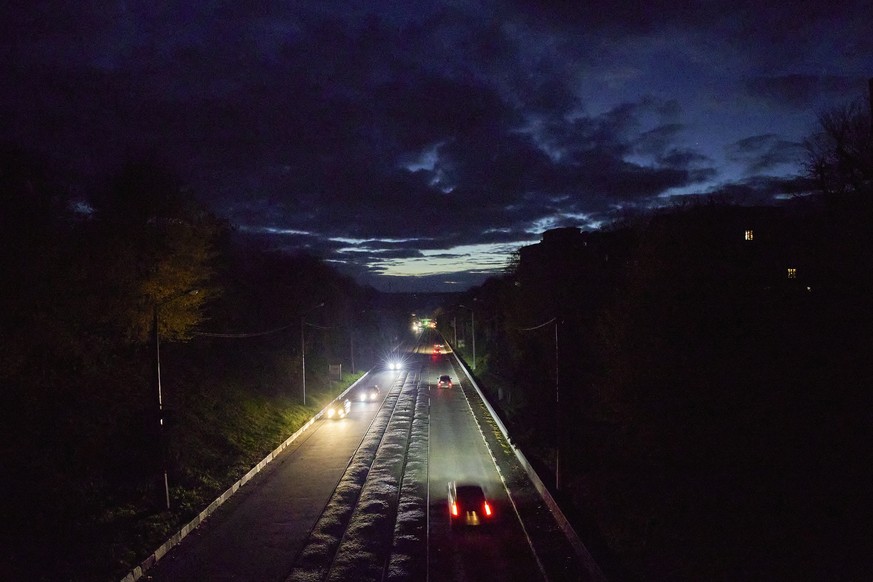 epa10275836 Cars drive on a non illuminated street during an electricity shortage in the city of Kharkiv, Ukraine, 30 October 2022. Power cuts were introduced all over the country, power operator Ukre ...