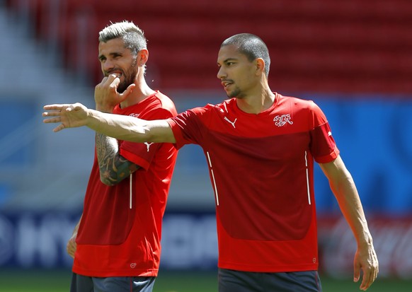 epa04256276 Switzerland national soccer team players GÃ¶khan Inler (R) gestures while chatting with Valon Behrami (L) during their team&#039;s training session in Brasilia, Brazil, 14 June 2014. Switz ...