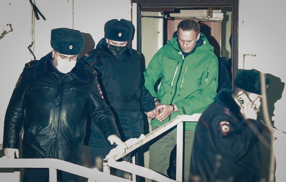 epa08946489 Russian opposition leader and anti-corruption activist Alexei Navalny (C) is escorted out of a police station in Khimki outside Moscow, Russia 18 January 2021. A Moscow judge on 18 January ...