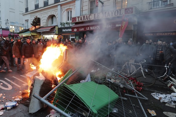 Members of Kurdish community stand next to a barricade on fire as they clash with police officers at the crime scene where a shooting took place in Paris, Friday, Dec. 23, 2022. Skirmishes erupted in  ...