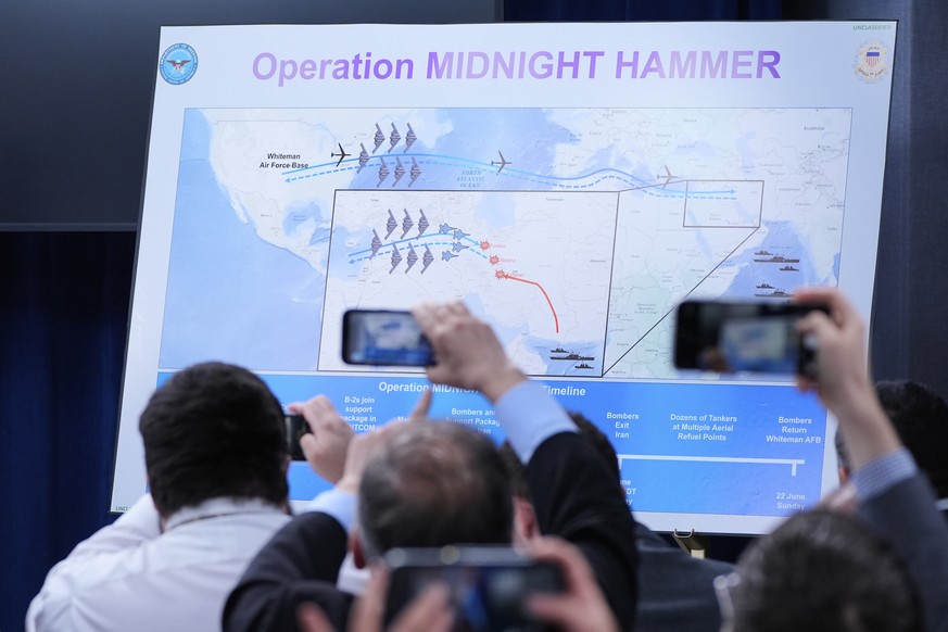 Reporters take photos of a displayed graphic as Defense Secretary Pete Hegseth and Joint Chiefs Chairman Gen. Dan Caine speak during a news conference at the Pentagon in Washington, Sunday, June 22, 2 ...