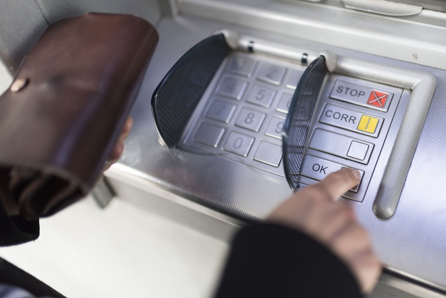 ZUM THEMA GELD STELLEN WIR IHNEN HEUTE, DONNERSTAG, 1. OKTOBER 2015, FOLGENDES NEUES BILDMATERIAL ZUR VERFUEGUNG --- A person enters the pin code on a key panel of a cash dispenser, photographed in Zu ...