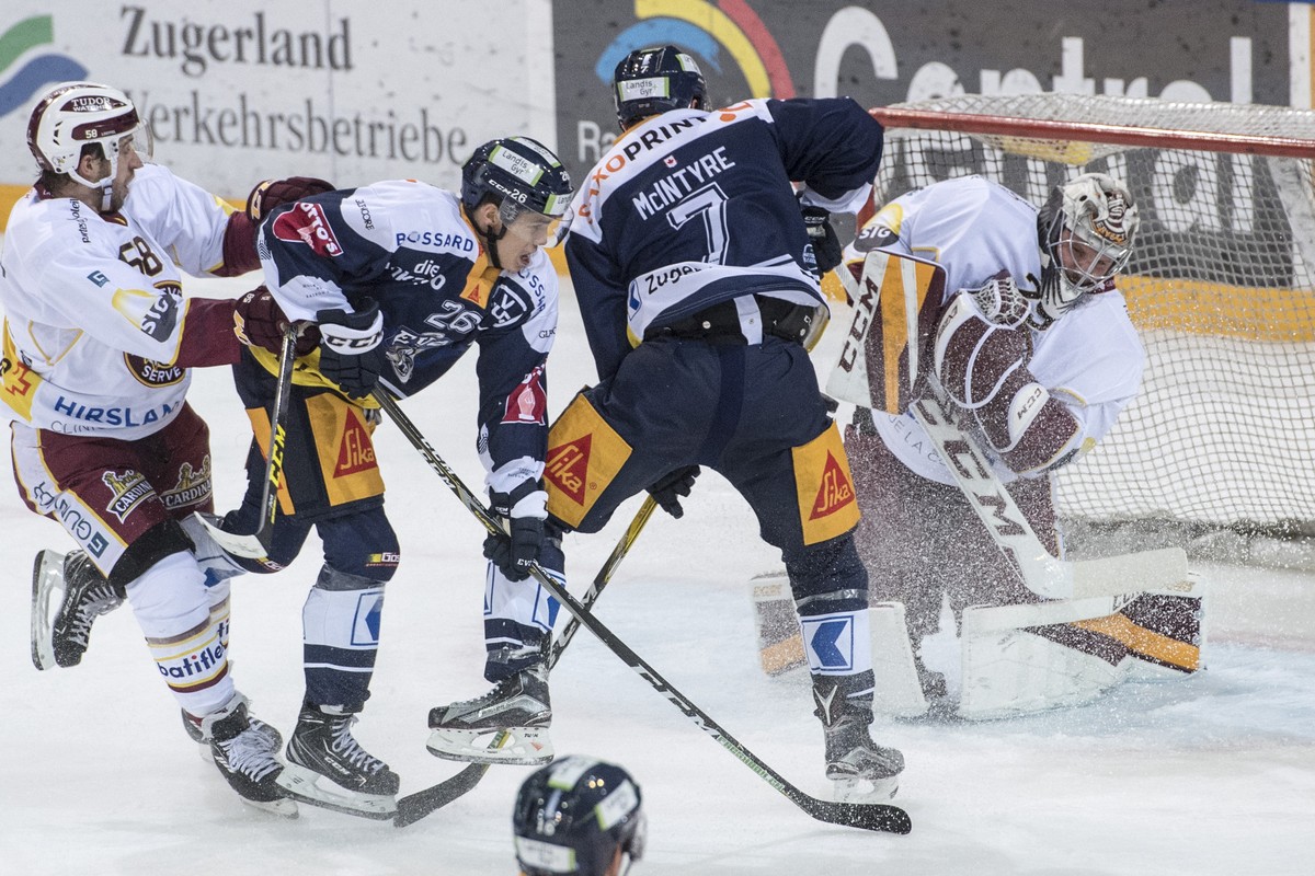 Reto Suri, 2. von links, von Zug im Spiel gegen Torhueter Robert Mayer, rechts, von Servette beim Eishockey Meisterschaftsspiel in der Qualifikation der National League zwischen dem EV Zug und Servett ...