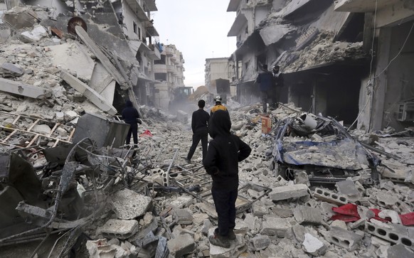 Syrian rescuers use a bulldozer to remove rubble of a destroyed building that covers a street after airstrikes in the town of Ariha, in Idlib province, Syria, Thursday, Jan. 30, 2020. Warplanes struck ...