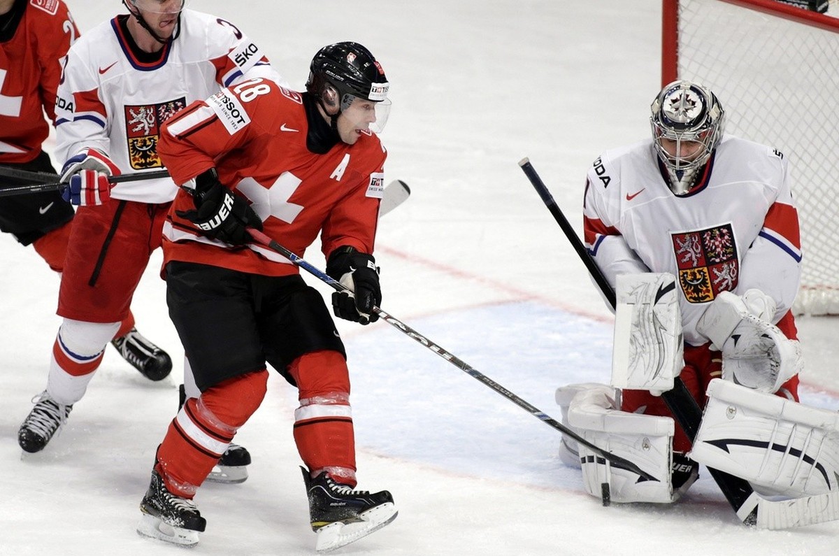 Switzerland's Martin Pluess, centre, vies for the puck with Czech's goaltender Ondrej Pavelec, right, in front of Switzerland's Nino Niederreiter, left, and Czech's Marek Zidlicky, ...