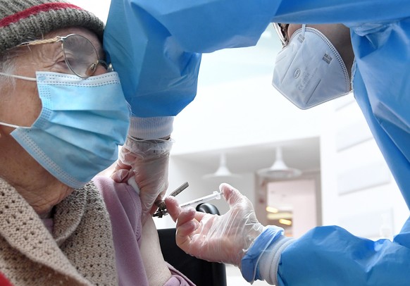 epa09095793 An elderly person is given a dose of the Covid-19 vaccine by a healthcare personnel at a vaccination center in Binasco, near Milan, Italy, 25 March 2021. EPA/DANIEL DAL ZENNARO