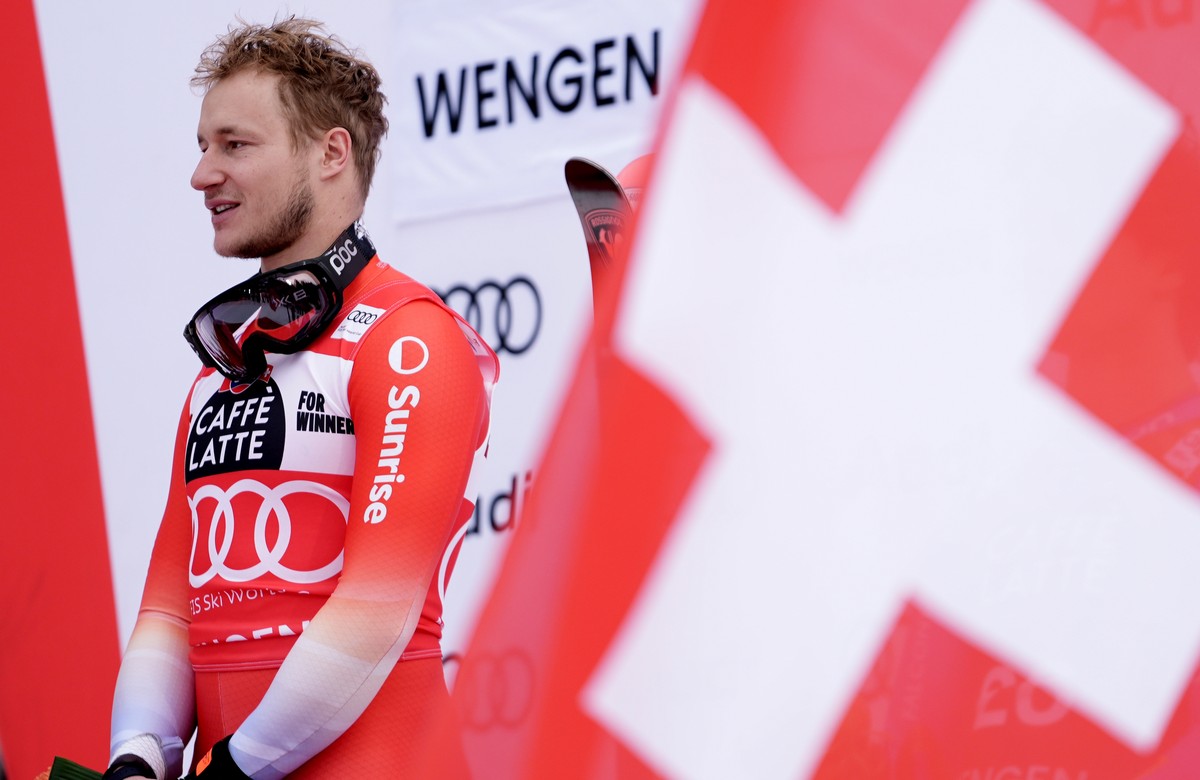 Switzerland's Marco Odermatt listens to the national anthem on the podium after winning an alpine ski, men's World Cup downhill, in Wengen, Switzerland, Saturday, Jan. 17, 2026. (AP Photo/Gi ...