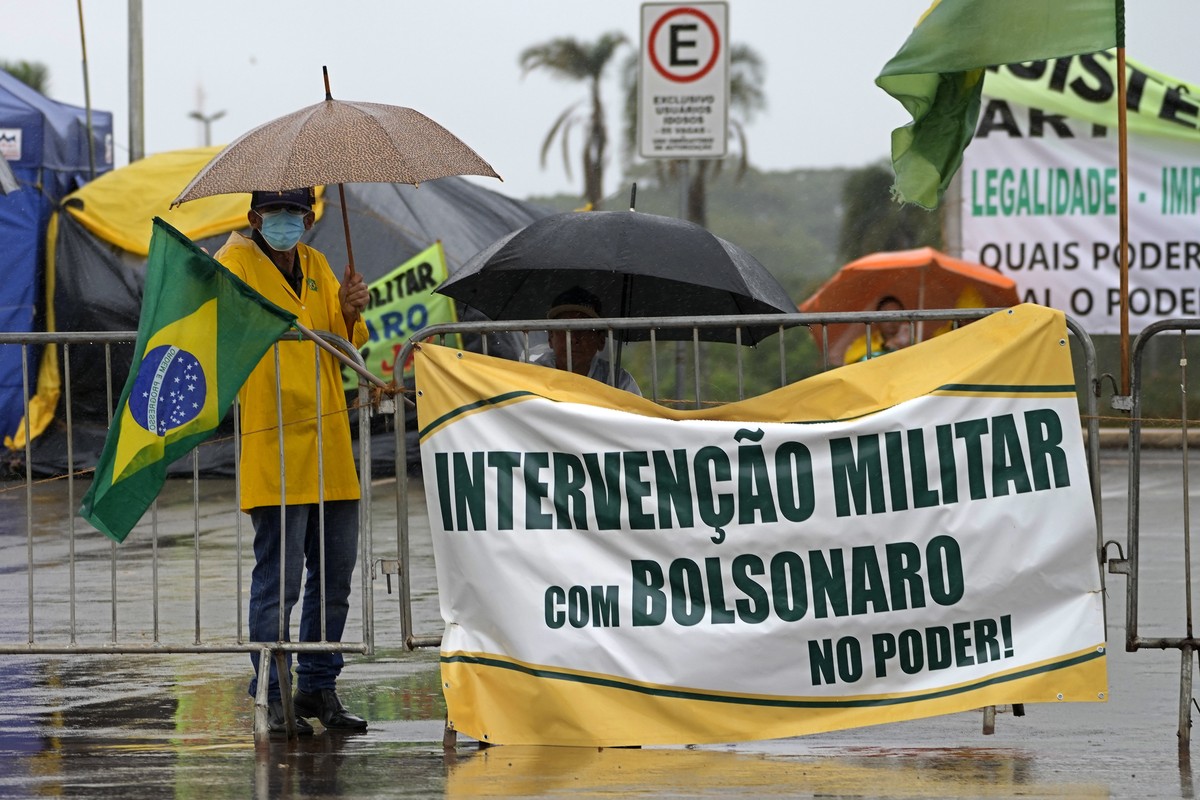 A supporter of outgoing President Jair Bolsonaro display banner with a message that reads in Portuguese "Military Intervention with Bolsonaro in Power", during a protest against the Oct. pre ...