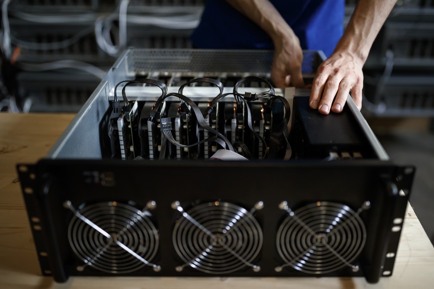 Alpine Mining co founder Theo Martinet performs routine equipment controls on a computer in a cryptocurrency mine in the small alpine village of Gondo, Switzerland, Monday, May 7, 2018. The village fo ...