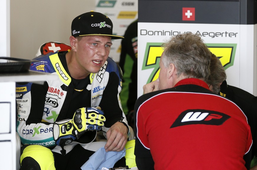 Dominique Aegerter of Switzerland talks to a member of his team in the garage area during an open practice for the Texas Moto2 race at the Circuit of the Americas Friday, April 10, 2015, in Austin, Te ...