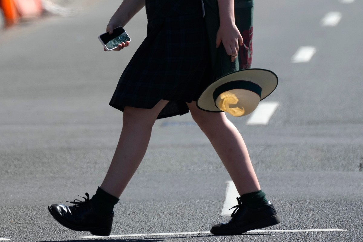 FILE - A school girl holds her phone while crossing a street in Sydney, on Nov. 8, 2024. (AP Photo/Rick Rycroft, File)
Australia Social Media