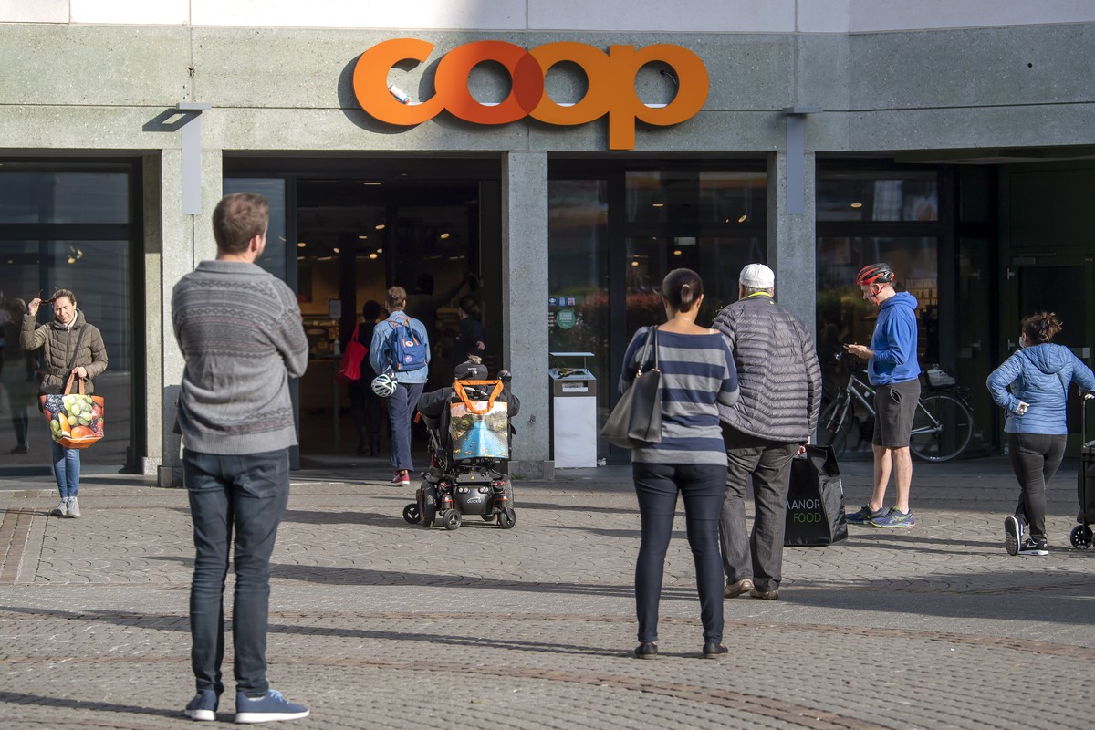 Des clients d'un magasin d'alimentations (Coop) doivent desormais patienter avant de pouvoir faire leurs courses, ce samedi 21 mars 2020 a Geneve. Pour faire face aux nouvelles exigences san ...