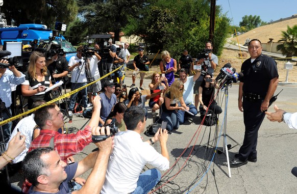 Los Angeles Police Department representative briefs the media as they wait outside the home of singer Chris Brown following an early morning 911 call from a woman there who asked for help in the Tarza ...