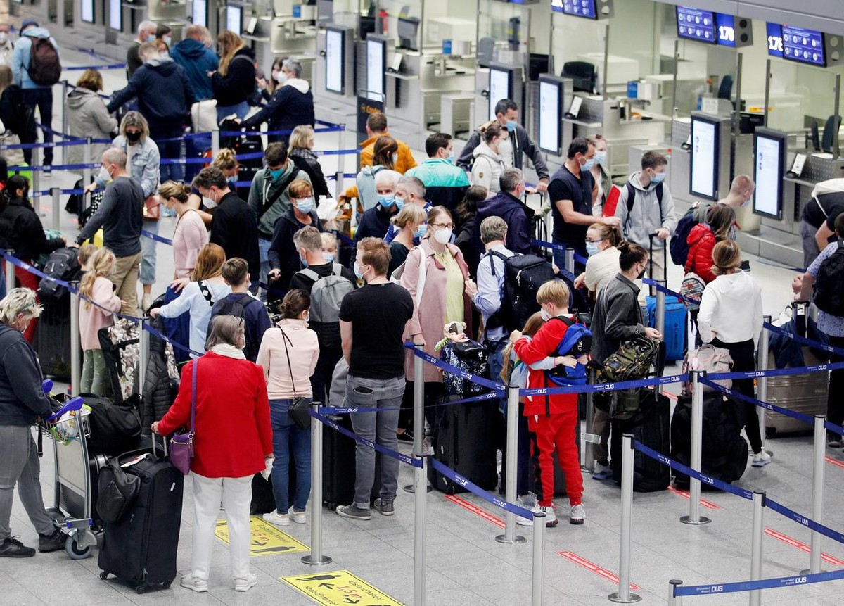 09.10.2021, Nordrhein-Westfalen, Düsseldorf: Reisende warten am Flughafen Düsseldorf auf ihre Abfertigung. In Nordrhein-Westfalen haben die Herbstferien begonnen. Foto: Roland Weihrauch/dpa +++ dpa-Bi ...