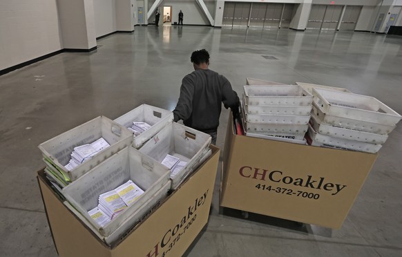 epa08830127 A worker delivers crates of ballots in preparation for the recount of ballots from the 03 November USA presidential election, at the Wisconsin Center in Milwaukee, Wisconsin, USA, 19 Novem ...