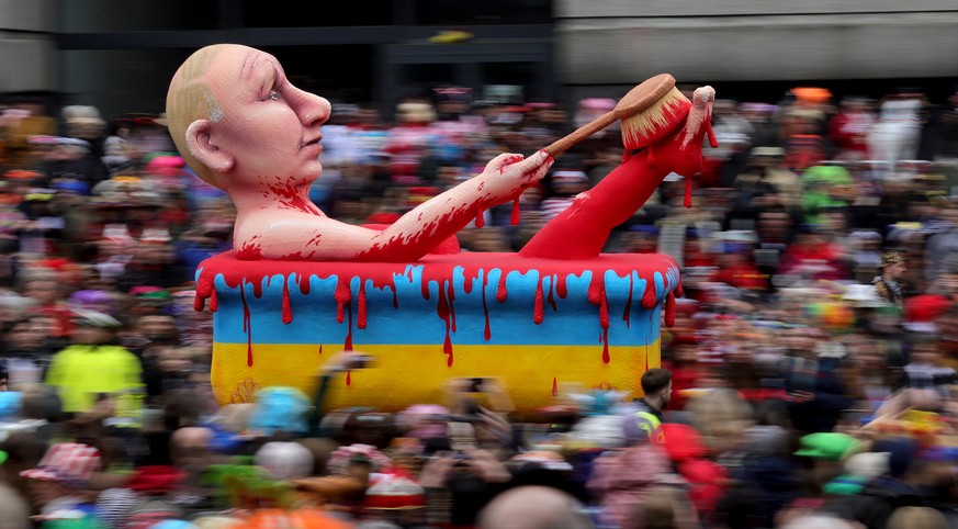 epa10479854 A carnival float depicting Russian President Vladimir Putin bathing in blood parades during the annual Rose Monday (Rosenmontag) parade in Duesseldorf, Germany, 20 February 2023. Rose Mond ...