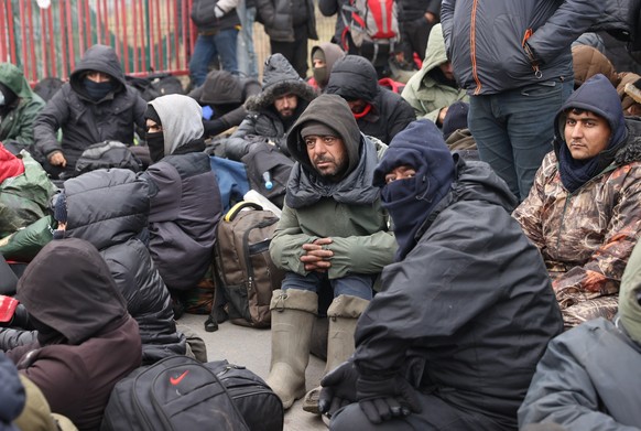 epa09583605 A handout photo made available by Belta news agency shows asylum-seekers, refugees and migrants gathered at the Bruzgi-Kuznica Bialostocka border crossing, Belarus, 15 November 2021. Asylu ...