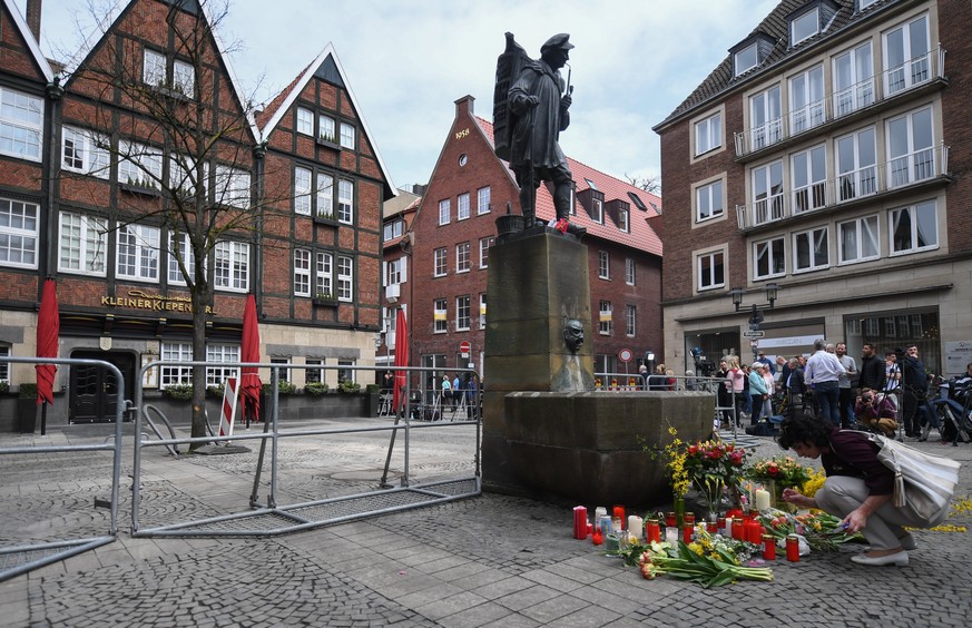 epa06654831 A women brings flowers to the crime scene in the inner city of Muenster, Germany, 08 April 2018, after a van drove into people sitting outside restaurants in the inner city on 07 April 201 ...